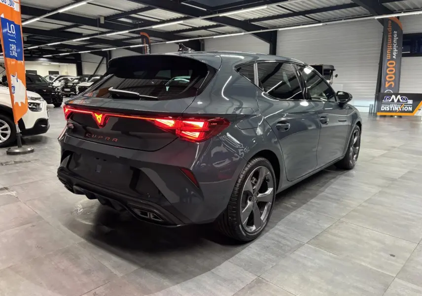 Vue 3/4 arrière droite d'une CUPRA Leon bleu Fjord avec feux arrière Tri-LED et double sortie d'échappement noire.