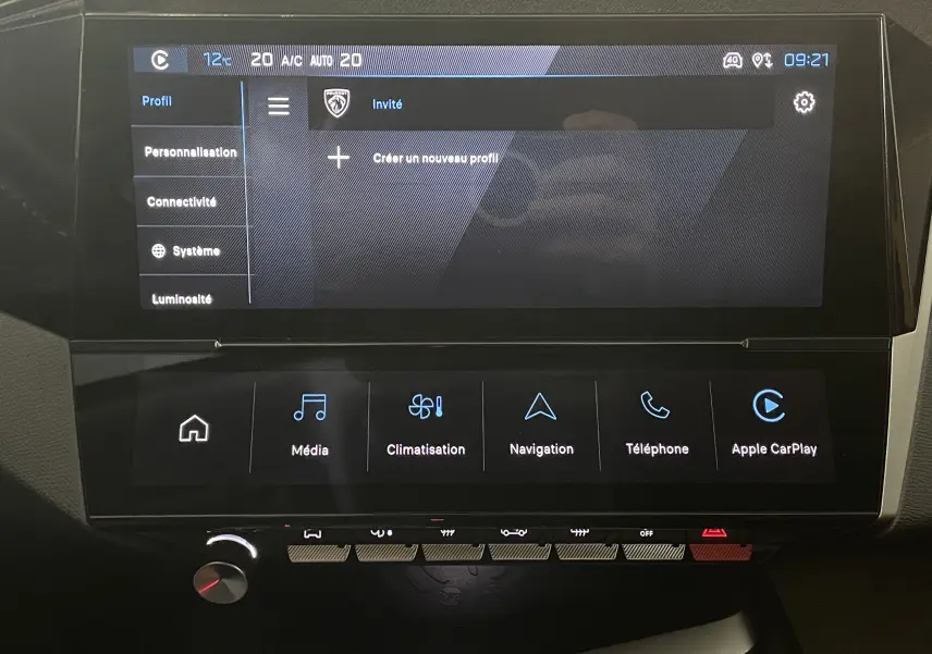 Écran tactile central du tableau de bord de la Peugeot 308 Hybrid 145, affichant les menus profils et climatisation.