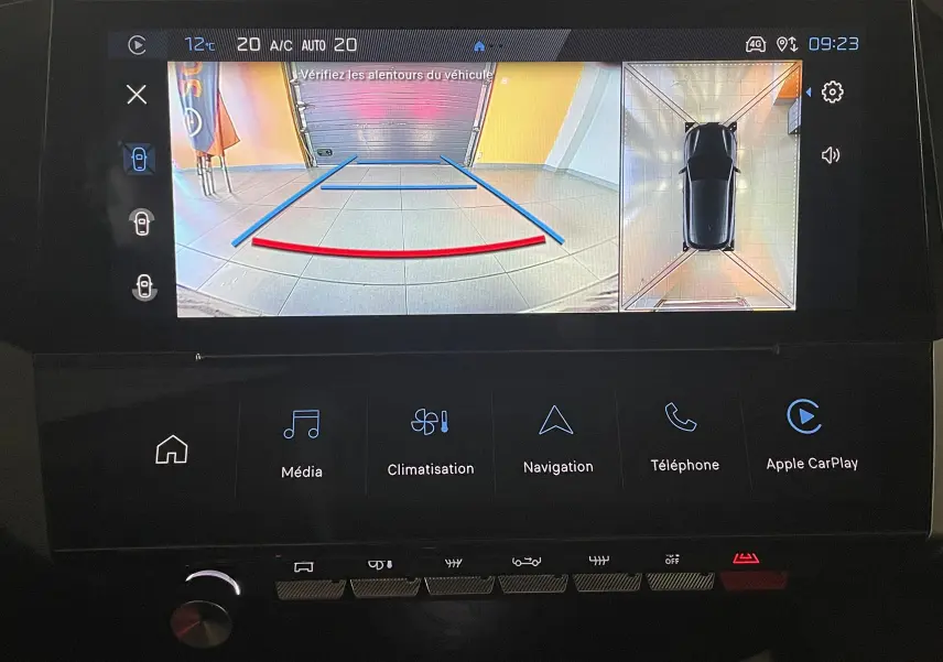 Écran tactile de la Peugeot 308 Hybrid 145 en mode caméra de recul avec vue 360° et guidage de trajectoire.
