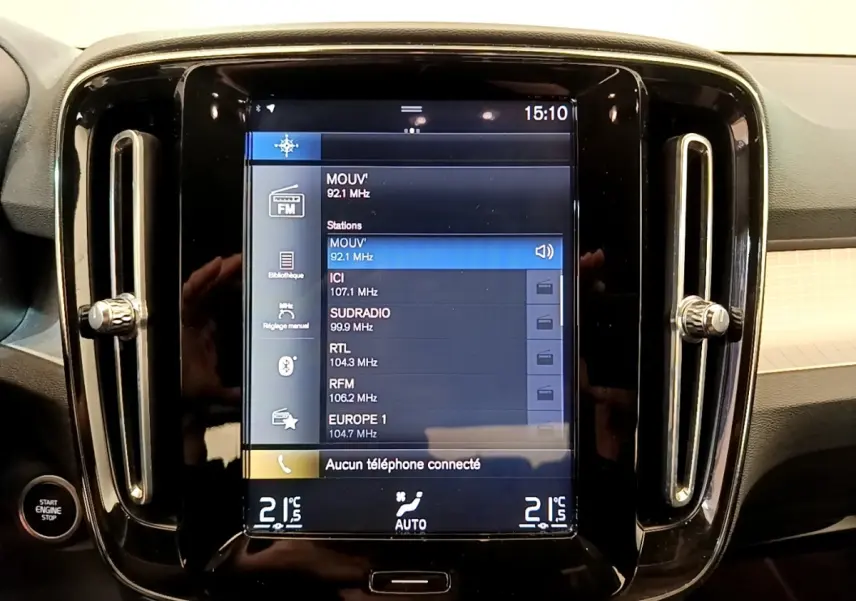 Vue rapprochée de l’écran tactile central noir du Volvo XC40 T2 Momentum avec commandes climatisation et radio affichées.