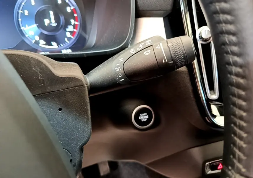 Gros plan sur la commande d’essuie-glace et le bouton démarrage du tableau de bord noir du Volvo XC40 T2 Momentum 2020.