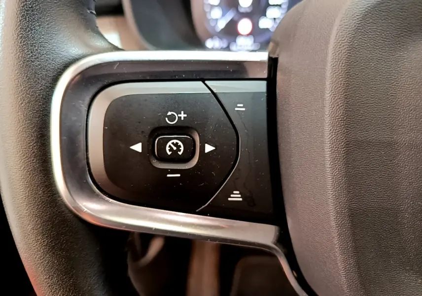 Gros plan sur les commandes de régulateur de vitesse au volant noir du Volvo XC40 T2 129 Momentum 2020.
