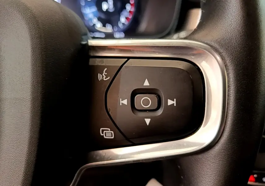 Gros plan sur les commandes multifonctions noires et argentées du volant du Volvo XC40 noir, version 2020.