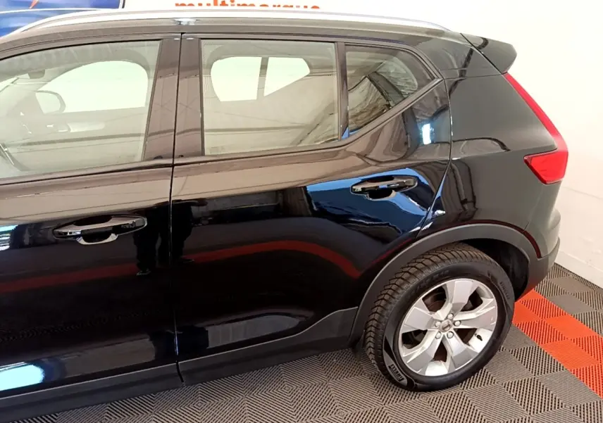 Vue latérale côté droit du Volvo XC40 T2 noir, mettant en valeur les jantes alliage et la ligne de toit avec spoiler.
