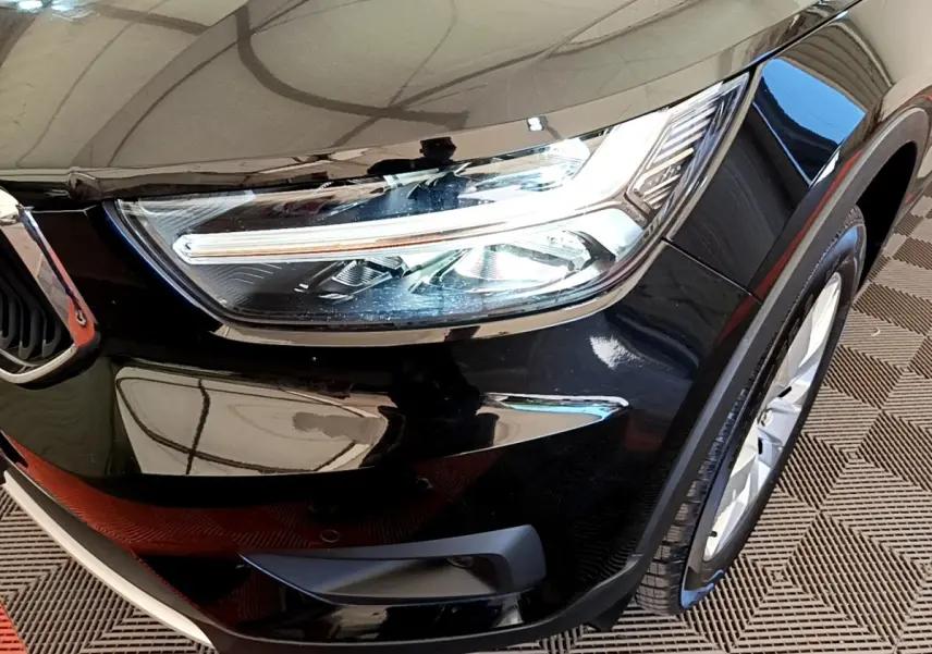 Gros plan sur l'avant droit noir brillant du Volvo XC40 T2 2020, mettant en valeur le phare LED et la roue.