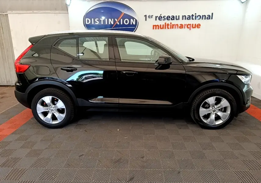 Profil droit du Volvo XC40 T2 noir 2020 garé en intérieur avec jantes argentées et toit noir.