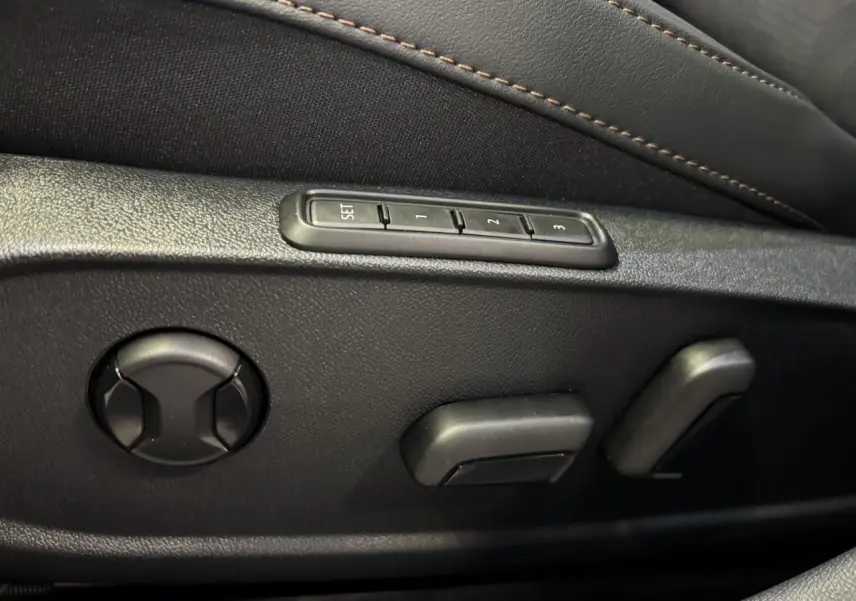 Détail des commandes de réglage électrique du siège conducteur noir avec surpiqûres cuivrées dans une CUPRA Leon 2026.