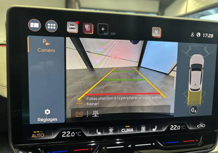 Écran tactile affichant la caméra de recul et l’aide au stationnement du CUPRA Leon gris Magnetic, vue intérieure.