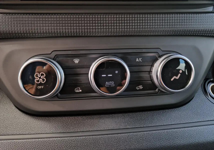 Gros plan sur les commandes de climatisation du Renault Trafic cabine approfondie blanc, avec réglages circulaires et affichage digital.