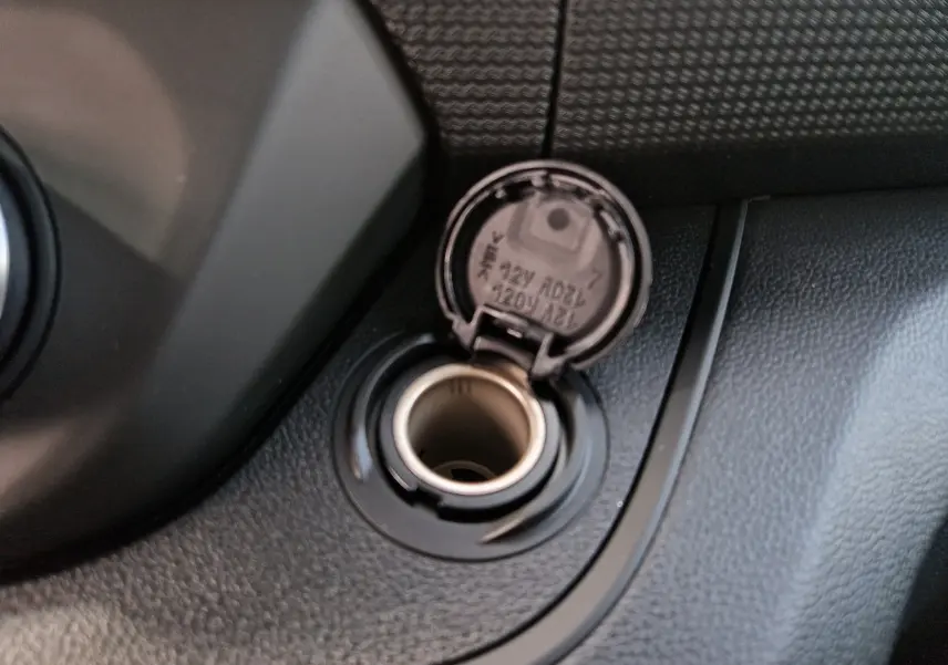 Prise 12V ouverte sur la console noire intérieure du Renault Trafic Cabine Approfondie blanc, version 2026.