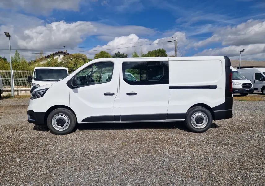 Profil droit d'un Renault Trafic cabine approfondie blanc, version L2H1 3T, avec vitres latérales et jantes acier.
