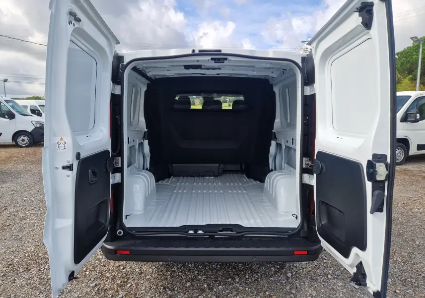 Vue arrière du Renault Trafic cabine approfondie blanc 2026 avec portes ouvertes et espace de chargement vide visible.
