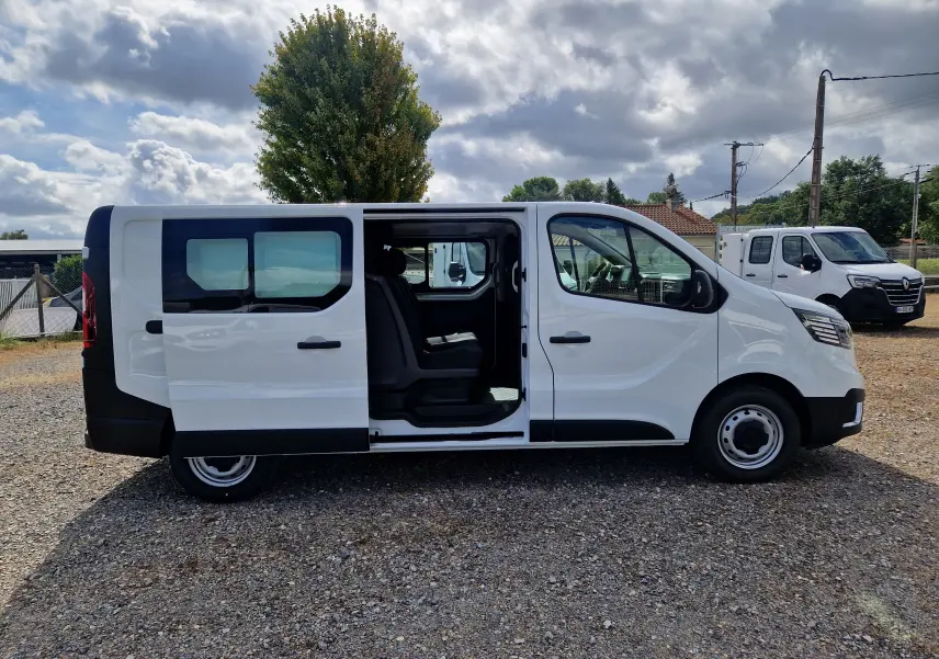 Vue latérale droite d’un Renault Trafic Cabine Approfondie blanc 2026 avec porte coulissante ouverte montrant l’intérieur.