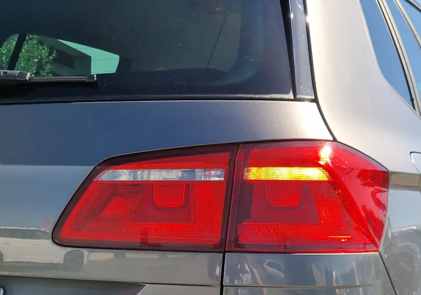 Feu arrière droit allumé d'une Volkswagen Golf Sportsvan gris Indium Metal, vue en gros plan sur l'arrière.