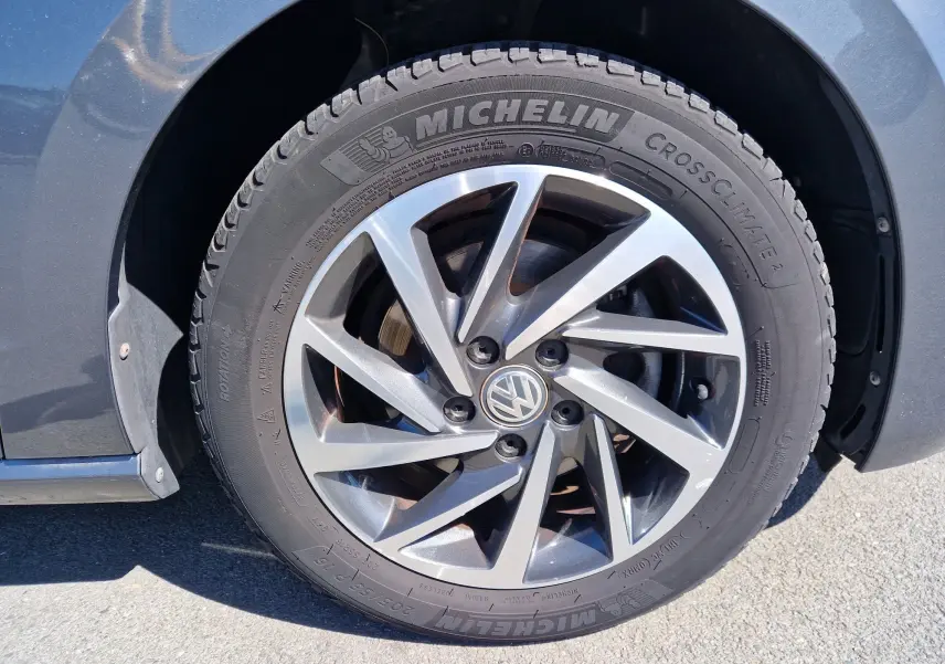 Gros plan sur la roue avant gauche gris indium métallisé d'une Volkswagen Golf Sportsvan avec jante alliage et pneu Michelin.