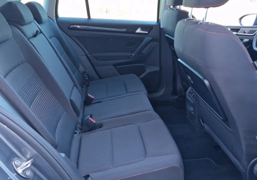 Vue intérieure côté gauche des sièges arrière gris foncé avec surpiqûres rouges du Volkswagen Golf Sportsvan 2017 gris Indium Metal.
