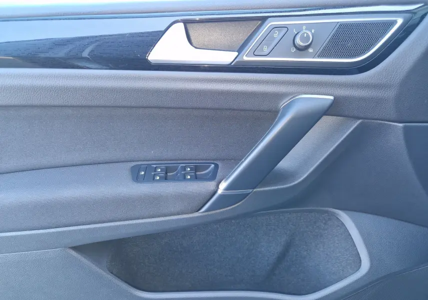 Vue rapprochée de la porte avant gauche de la Volkswagen Golf Sportsvan gris Indium, avec commandes de vitres et rétroviseurs.