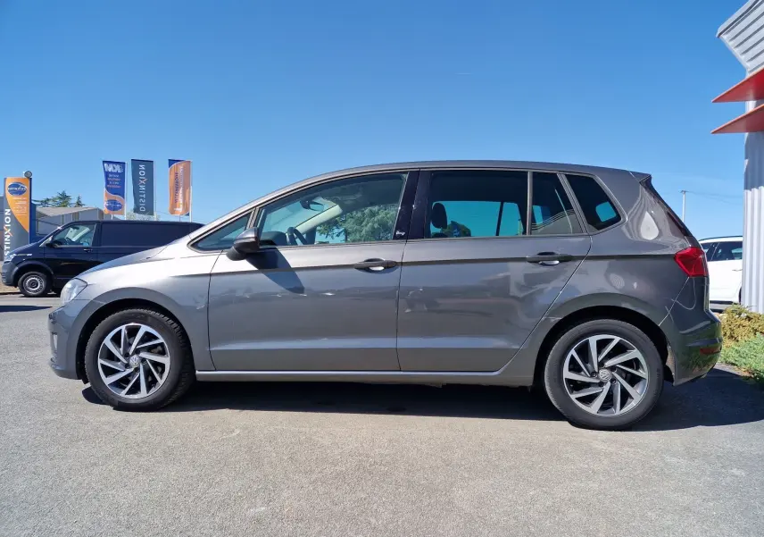 Profil côté gauche d’un Volkswagen Golf Sportsvan gris Indium Metal 2017 avec jantes alliage et vitres teintées.