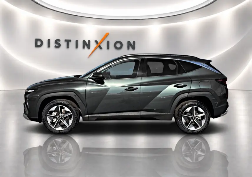 Vue profil droit du Hyundai Tucson 1.6 t-gdi 239 hybride vert métallisé avec jantes alu 18 pouces dans un showroom.