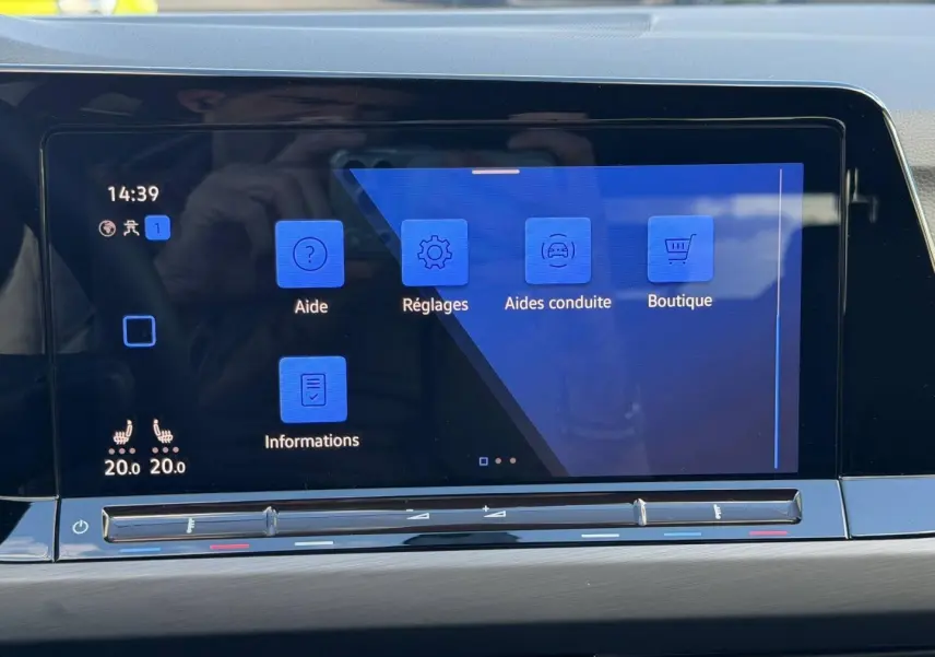 Écran tactile central de la Volkswagen Golf 2024 affichant les menus d’aide, réglages et conduite, intérieur gris.