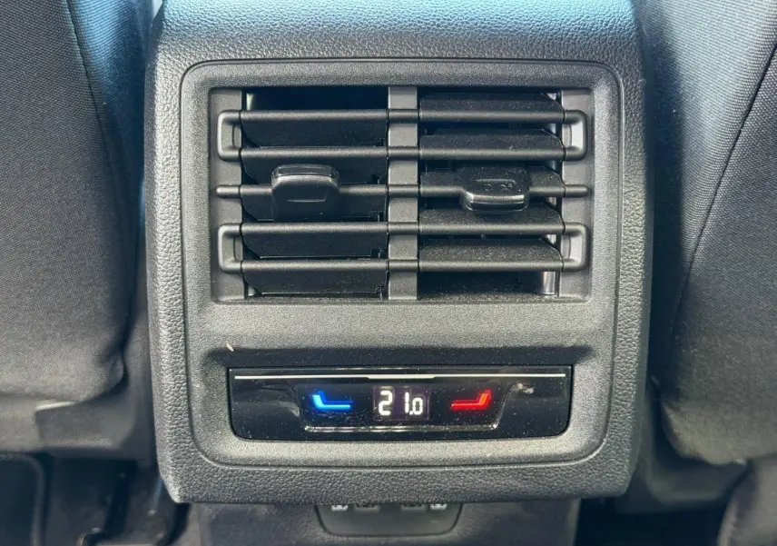 Gros plan sur la ventilation arrière et le réglage de la température à 21°C dans l’habitacle gris du Volkswagen Golf 2024.
