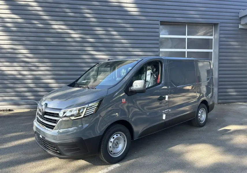 Renault Trafic Fourgon gris urbain vu en 3/4 avant droit, avec jantes acier et caméra de recul intégrée.