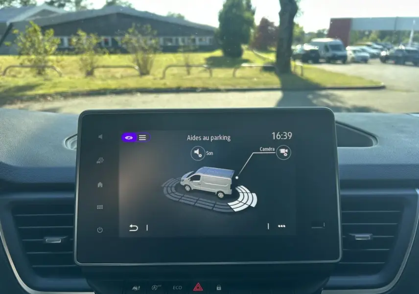 Écran central du Renault Trafic Fourgon gris urbain montrant l'aide au parking avec caméra de recul active.