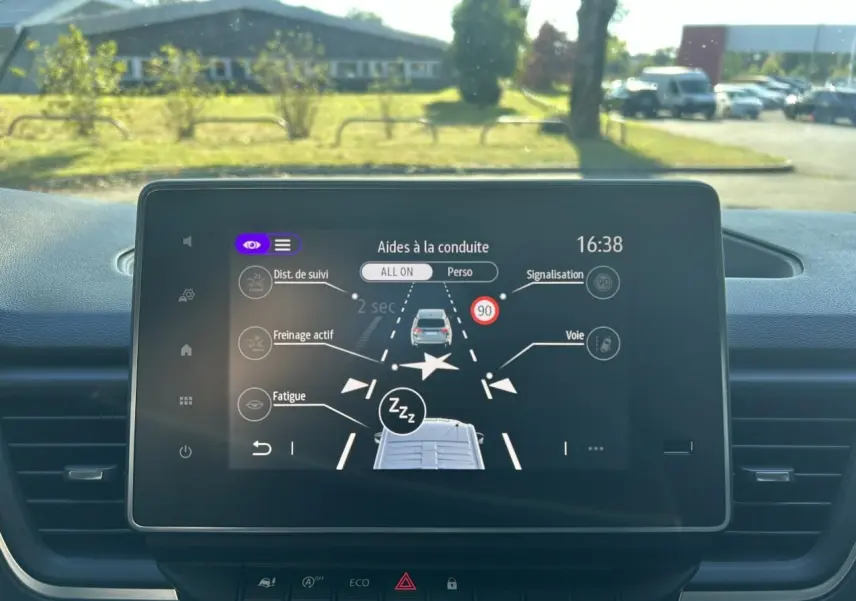 Écran central du Renault Trafic Fourgon gris urbain 2025 montrant les aides à la conduite et alertes de sécurité.