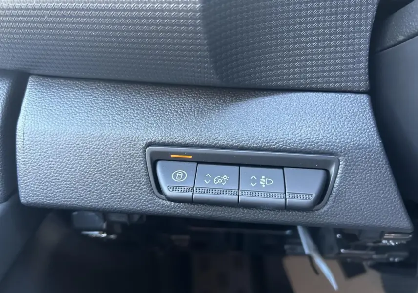 Boutons de réglage d'éclairage et verrouillage sur tableau de bord noir du Renault Trafic Fourgon Gris Urbain, vue intérieure rapprochée.