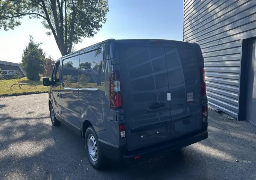 Vue 3/4 arrière droite d'un Renault Trafic Fourgon gris urbain avec portes arrière fermées et jantes acier.