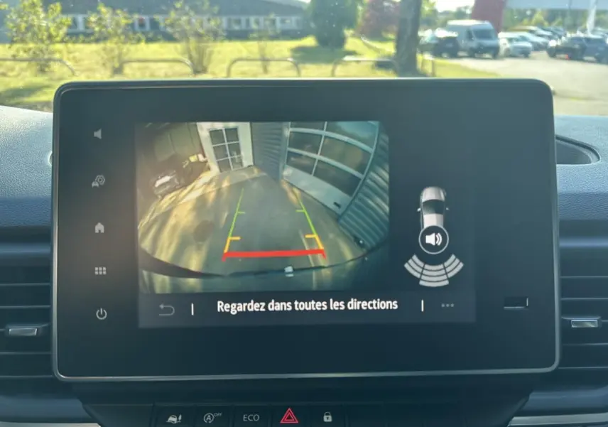 Écran central montrant la caméra de recul active du Renault Trafic Fourgon gris urbain avec guidage de trajectoire coloré.