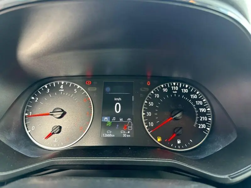 Vue rapprochée du tableau de bord numérique de la Renault Clio 2023, affichant vitesse à 0 km/h et compteurs gris.