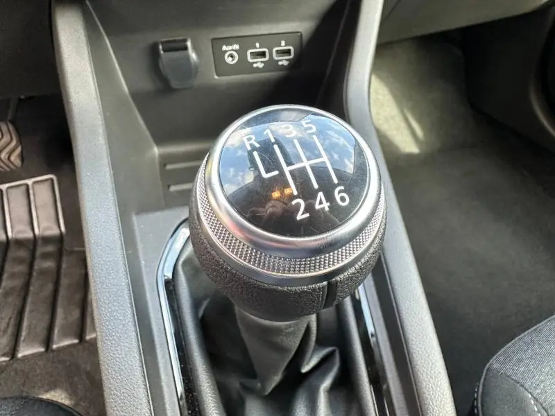 Gros plan sur le levier de vitesses manuel noir de la Renault Clio 1.0 TCe 90ch Equilibre 2023, avec ports USB en arrière-plan.