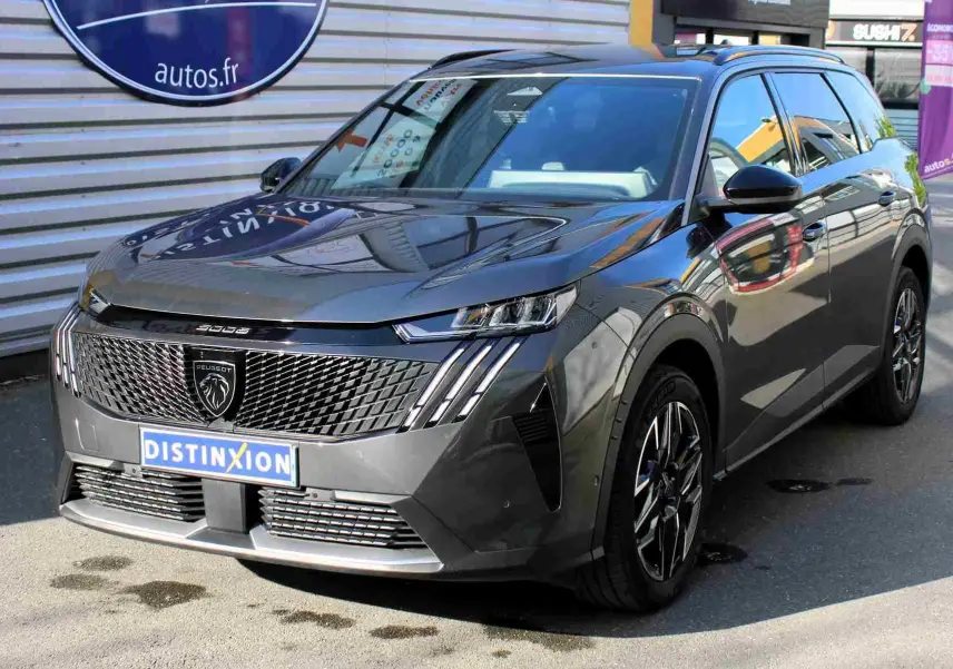 Peugeot 5008 gris titane métal en vue 3/4 avant, avec calandre distinctive et jantes alliage noires.