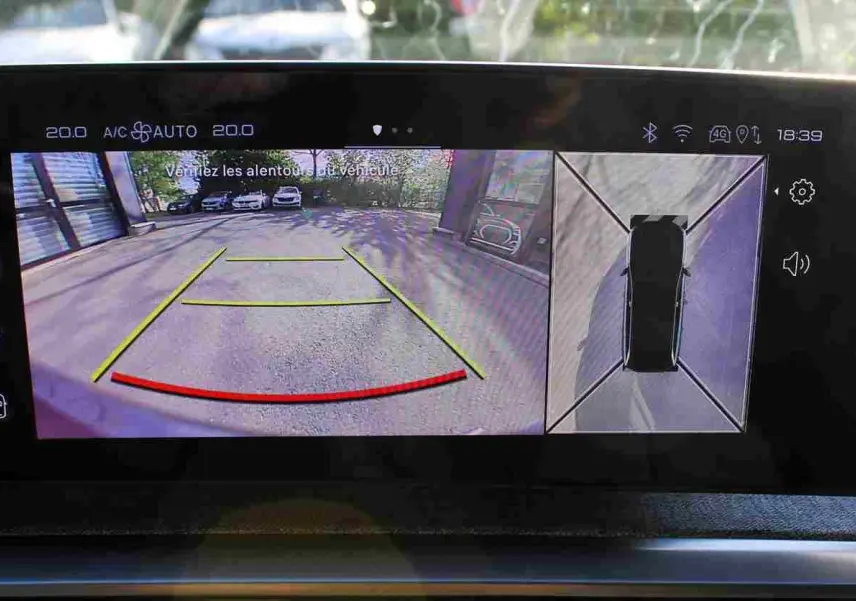 Écran multimédia du Peugeot 5008 Hybrid montrant la caméra de recul avec vue arrière et top-down en extérieur.