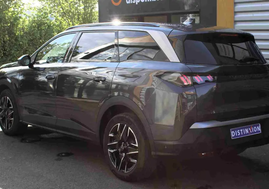 Peugeot 5008 gris titane métal en 3/4 arrière droit, avec jantes noires et toit contrasté argenté.