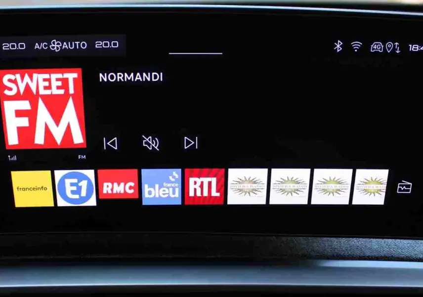 Écran tactile central du Peugeot 5008 III Hybrid 2025 affichant la radio Sweet FM et plusieurs stations FM.