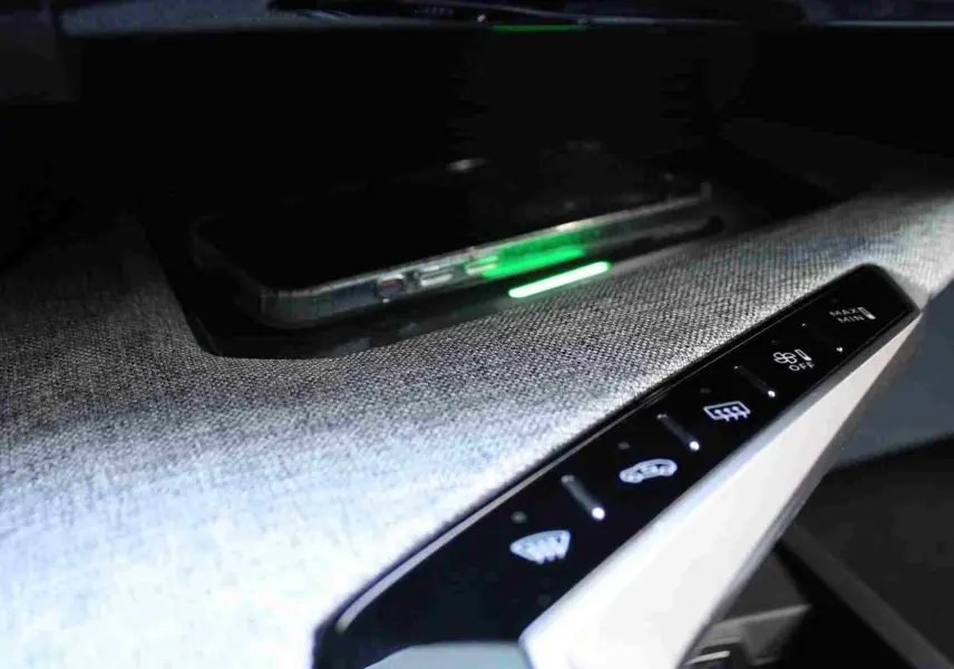 Détail du tableau de bord du Peugeot 5008 III Hybrid 2025 avec console en tissu gris et commandes tactiles éclairées.