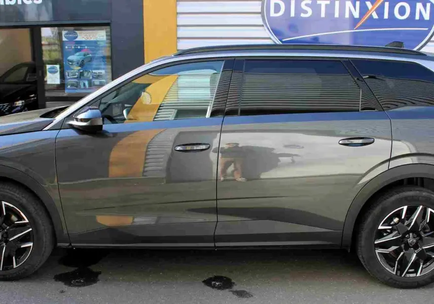 Vue latérale droite du Peugeot 5008 gris titane métal 2025 avec jantes alliage noires et toit noir contrasté.