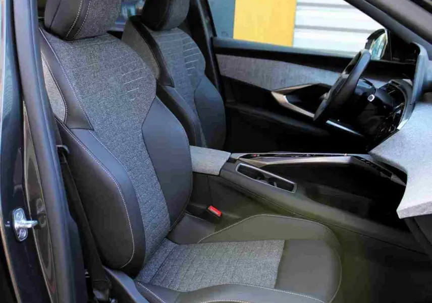 Vue intérieure côté conducteur du Peugeot 5008 gris titane, sièges bi-matière tissu et cuir avec surpiqûres blanches.