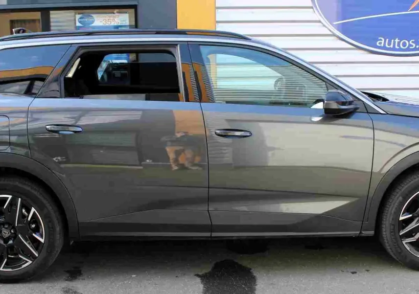 Profil droit du Peugeot 5008 gris titane métal 2025 avec jantes noires et toit ouvrant panoramique.