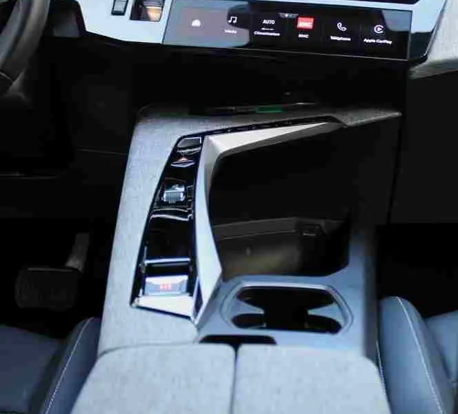Vue intérieure rapprochée de la console centrale et du tableau de bord numérique du Peugeot 5008 Hybrid 2025, finition tissu gris noir.