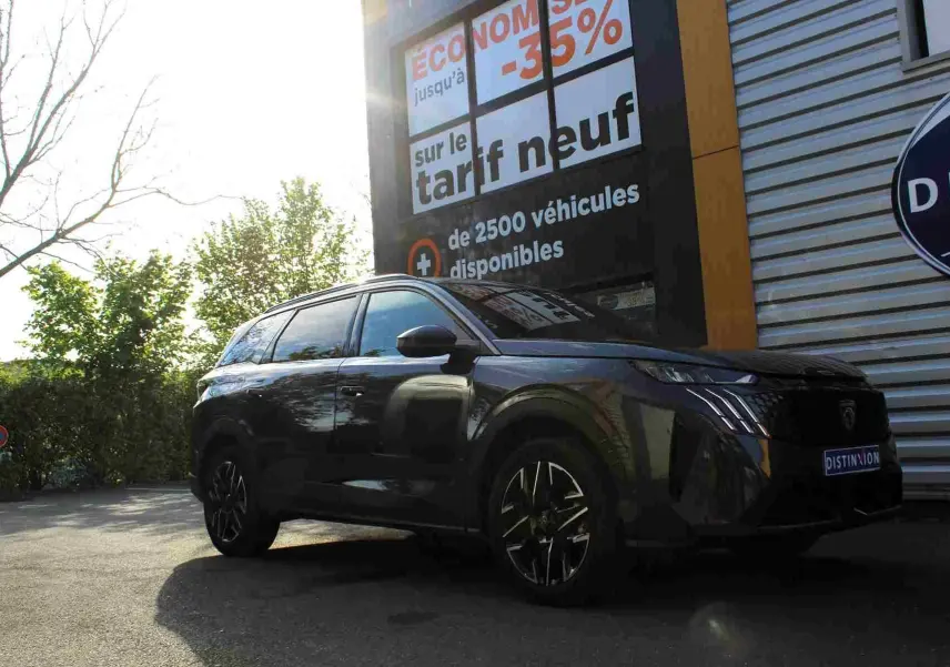 Peugeot 5008 gris titane métal vue 3/4 avant droit, avec calandre distinctive et jantes alliage noires.
