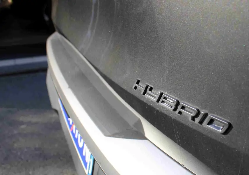 Gros plan sur l'arrière gris titane métallisé d'un Peugeot 5008 Hybrid avec le badge "HYBRID" visible.