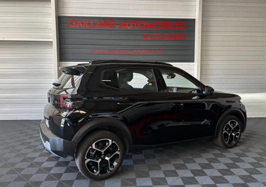 Vue latérale droite d'une Citroën C3 Turbo 100 BVM6 MAX noire, avec jantes distinctives et spoiler arrière visible.