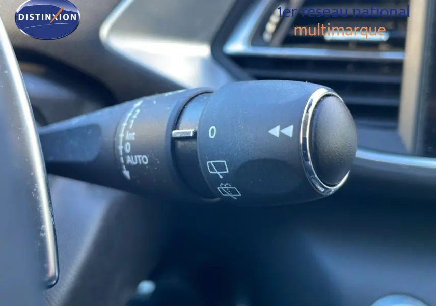 Gros plan sur la commande d’essuie-glace à gauche du volant dans l’habitacle d’une Peugeot 308 gris Artense 2019.