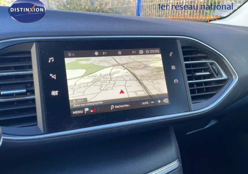Écran tactile central du tableau de bord de la Peugeot 308 gris Artense, affichant la navigation GPS en extérieur.