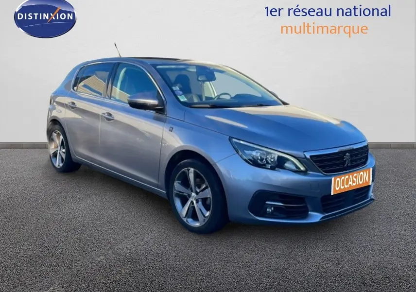 Peugeot 308 gris Artense métal vue 3/4 avant droit avec jantes alliage et calandre noire brillante.