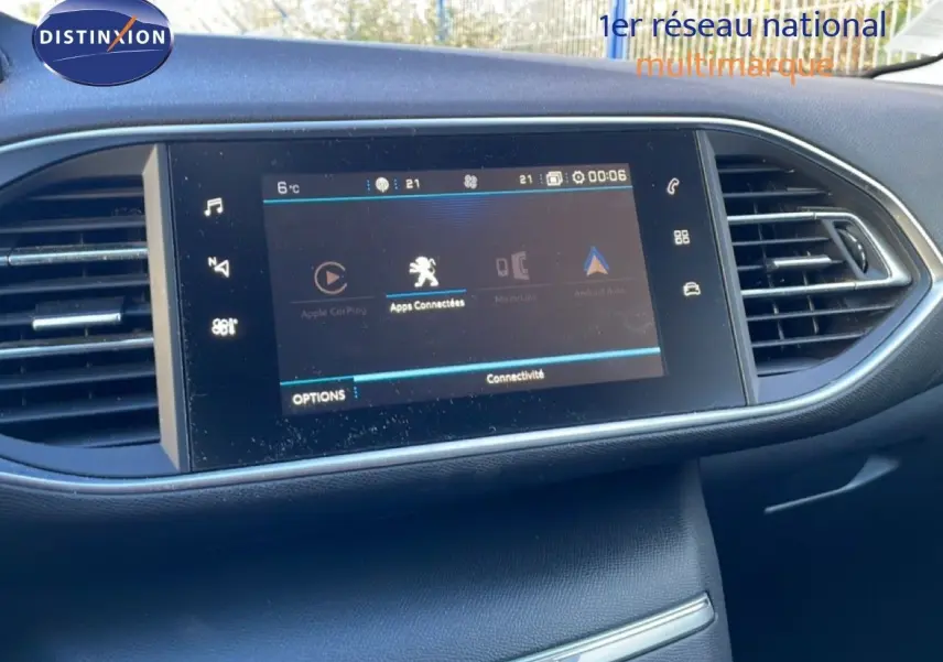 Vue rapprochée de l’écran tactile central du tableau de bord de la Peugeot 308 gris Artense, affichant les options de connectivité.