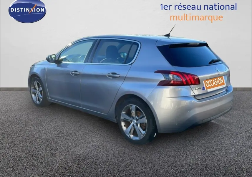 Peugeot 308 gris Artense métal vue 3/4 arrière droit, hayon fermé et jantes alliage visibles.